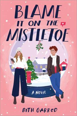 Cover of Blame It on the Mistletoe by Beth Garrod. Cover is pink with a large snow globe that depicts a house, large evergreen tree decorated with lights and mistletoe at the top of the snow globe. There is a young Caucasian female on her phone on the left side of the snow globe. On the right side of the snow globe is a young Caucasian male looking at the femal.