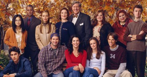 The cast pose in front of a background of yellow and orange autumn leaves.